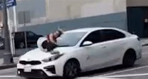 woman clings to car french bulldog